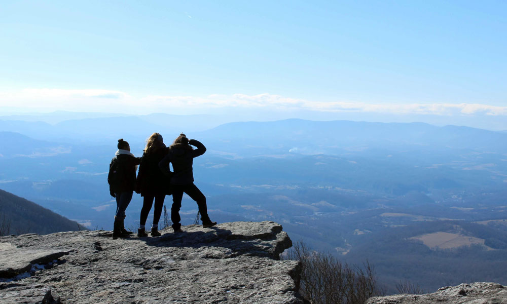 three torc team members standing on a mountainous overlook.
