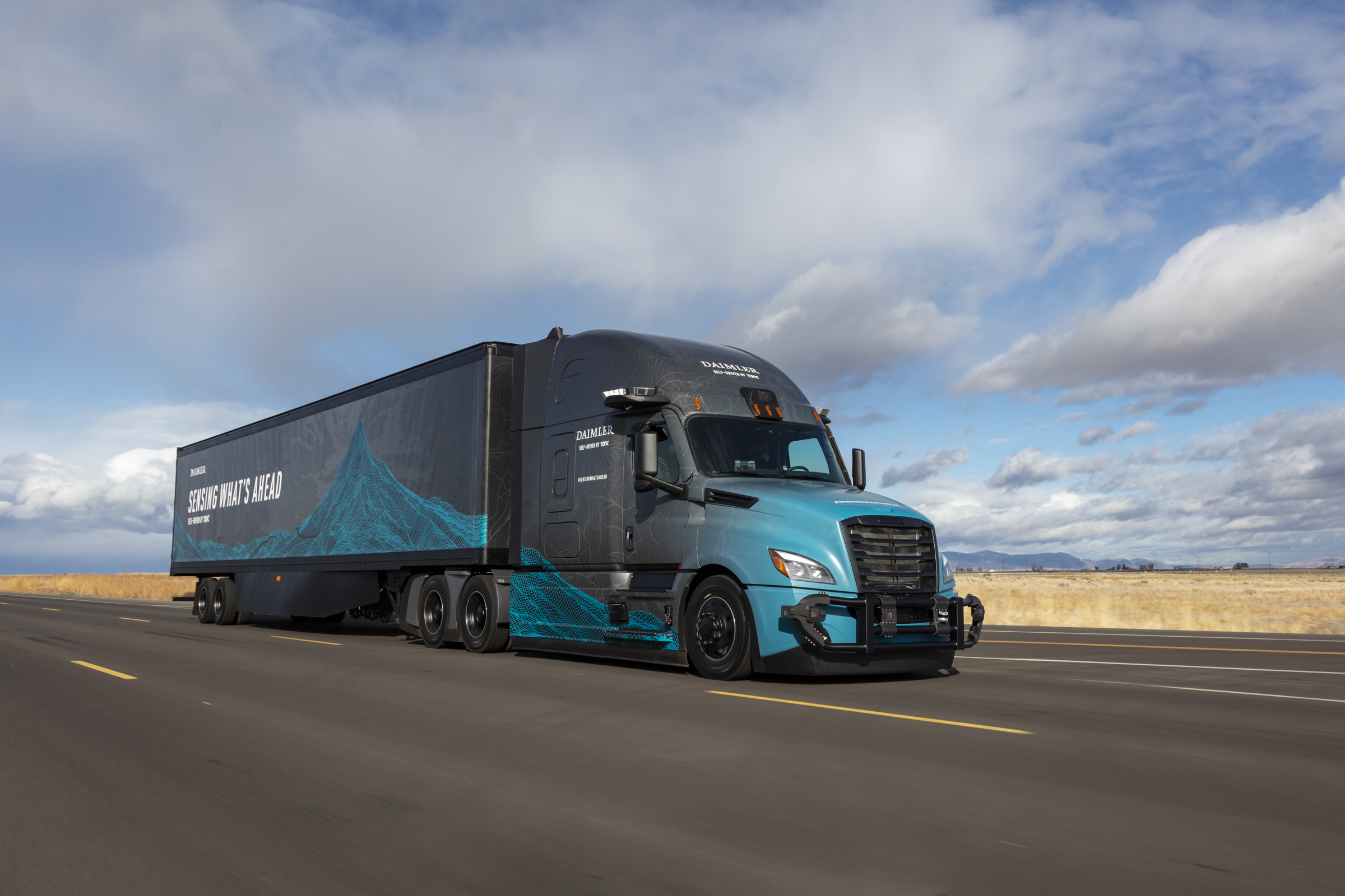 A Torc-Daimler automated truck drives down a highway.